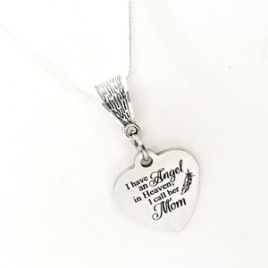 May include: Silver necklace with a heart-shaped pendant that reads "I have an Angel in Heaven, I call her Mom".