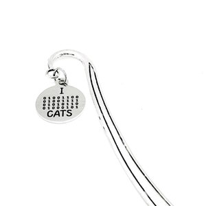 Può includere: Segnalibro d'argento con un ciondolo rotondo che dice "I  0100111100 011001011110 011010011100 011001011101 0100000101 CATS".