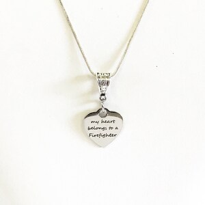 May include: Silver necklace with a heart pendant that says "my heart belongs to a Firefighter".
