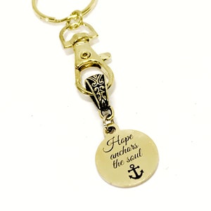 May include: Gold-tone keychain with a round charm that reads "Hope anchors the soul" with an anchor symbol.