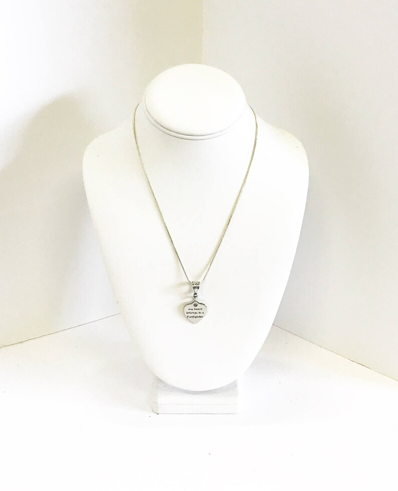 May include: A silver chain necklace with a heart-shaped pendant that reads "My sister is my soulmate, my forever friend".