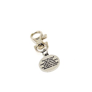 May include: Silver keychain with a round charm that has the Bible verse "Love the Lord your God with all your heart, all your soul, and all your mind. Matthew 22:37" engraved on it.