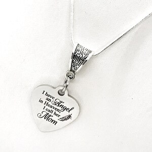 May include: Silver necklace with a heart-shaped pendant that reads "I have an Angel in Heaven, I call her Mom".