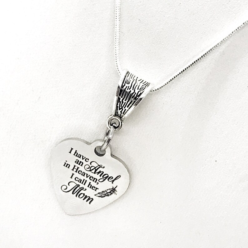 May include: Silver necklace with a heart-shaped pendant that reads "I have an Angel in Heaven, I call her Mom".