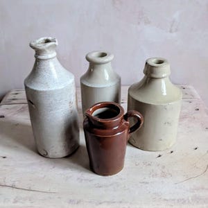 A collection of four antique Stoneware bottles & jug- posey vases