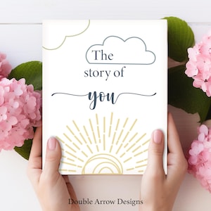 May include: A rectangular white sign featuring a blue cloud outline with the text The story of you in blue script and block lettering, accented by a yellow sun graphic at the bottom and a partial cloud outline in the top left corner.