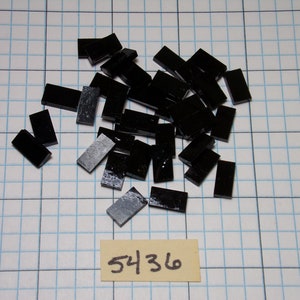 May include: A pile of black rectangular tiles, scattered on a white grid background. The number 5436 is written on a yellow piece of paper below the tiles.
