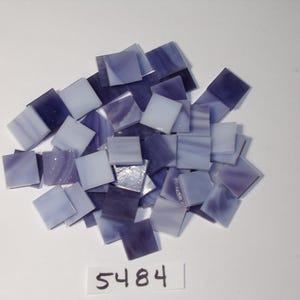 May include: A collection of small, square mosaic tiles in shades of purple and white. The tiles are scattered on a white surface. A small white label with the number "5484" is visible.