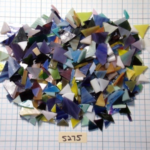 May include: A large pile of colorful glass mosaic tiles in various shapes and sizes. The tiles are mostly triangular and have a variety of colors, including blue, green, purple, yellow, and white.