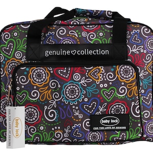 May include: A black sewing machine bag with a colorful floral and heart pattern. The bag has a front pocket, handles, and the text "genuine collection" and "baby lock" on it. The bag is designed for sewing enthusiasts.