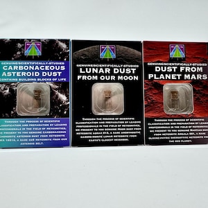 May include: Three boxes of genuine dust samples: Carbonaceous Asteroid Dust, Lunar Dust from our Moon, and Dust from Planet Mars. Each box contains a small vial of dust. The boxes have text and a logo.