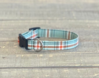 May include: A blue, brown, and red plaid dog collar with a black plastic buckle and a silver metal D-ring.