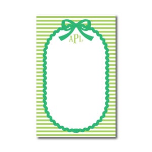 May include: Green and white striped notepad with a green scalloped oval frame and a green bow with the monogram "APL" in the center.