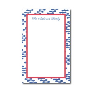 May include: White notepad with a blue and white patterned border and a red border. The text "The Anderson Family" is printed at the top of the notepad.