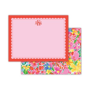 May include: Red and pink stationery set with a scalloped border and a monogram "AKG" in red. The stationery is decorated with a floral pattern.