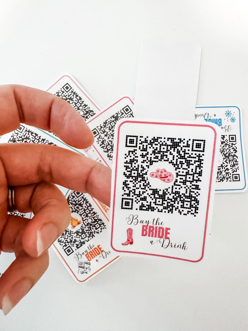 May include: Four white cards with black and white QR codes. Each card has a pink and white design with the text "Buy the Bride a Drink" and a pink cowboy boot graphic.