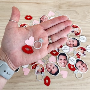 Pu&ograve; includere: Confetti rosa e rossi con un anello, labbra, cuori, un cane e volti di persone. Il coriandoli dice "Jenna's Bachelorette".