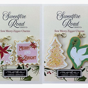 May include: Two sets of gold zipper charms with a Christmas theme. The first set features a red poinsettia flower and a pink and white flower. The second set features a gold Christmas tree and a white dove with green wings.