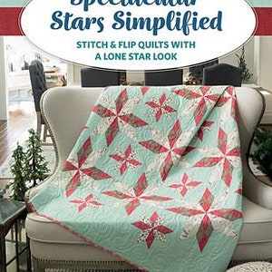 May include: A book titled "Spectacular Stars Simplified" with a teal, red, and brown quilt on a white armchair. The book cover features the title in a white font with a red star.