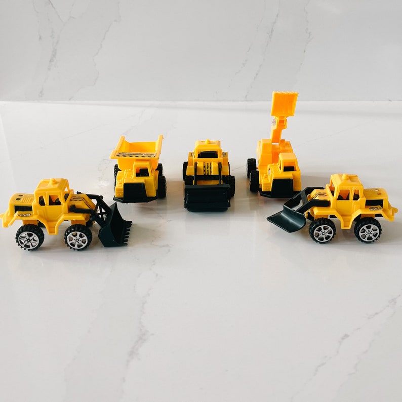 May include: Five yellow toy construction vehicles, including a dump truck, a bulldozer, a backhoe, a front loader, and a small excavator. The toys are made of plastic and have black wheels.