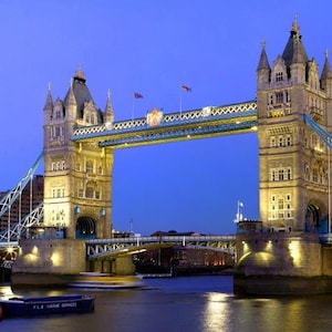 Peut inclure: Vue du Tower Bridge à Londres, en Angleterre, au crépuscule. Le pont est illuminé de lumières, et l'eau en contrebas est calme et réfléchissante. Le pont est une destination touristique populaire et un symbole de Londres.