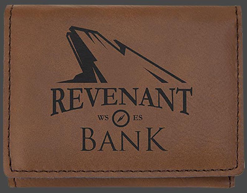 May include: A brown leather wallet with the words "Revenant Bank" and a compass logo engraved on the front.
