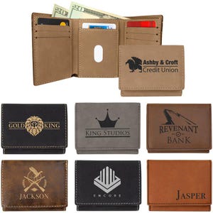 May include: A set of ten tri-fold wallets with different designs and logos. The wallets are made of brown, black, and gray leather. The logos include "Gold King", "King Studios", "Revenant Bank", "Jackson", "Encore", and "Jasper".
