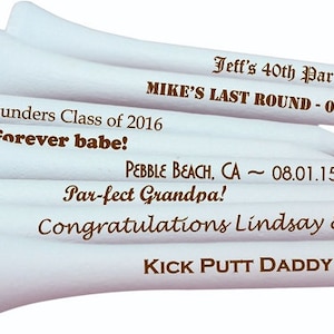 May include: A stack of white golf tees with personalized messages in brown text. The messages include "Jeff's 40th Par-Tee", "MIKE'S LAST ROUND - 07.16.16", "Jeff Saunders Class of 2016", "Forever babe!", "PEBBLE BEACH, CA ~ 08.01.15", "Par-fect Grandpa!", "Congratulations Lindsay & Matt!" and "KICK PUTT DADDY!! LOVE MAYA".