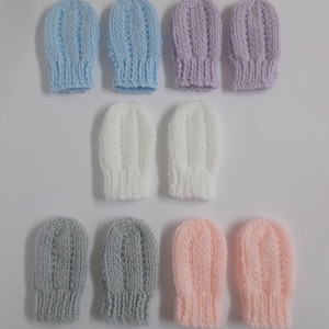 May include: Eight pairs of knitted baby mittens in various colours, including light blue, lavender, white, grey, and pink. The mittens are all the same style, with a simple ribbed pattern.