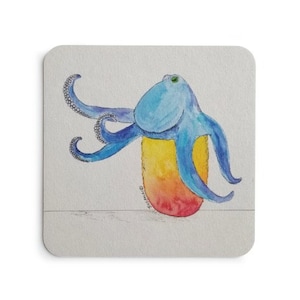 May include: A blue octopus with a green eye sits on top of a rainbow-coloured, oval-shaped object. The octopus has eight tentacles and is drawn in a watercolour style.