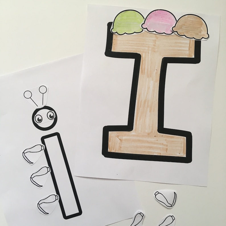 May include: A black and white illustration of the letter I with three ice cream cones on top. The ice cream cones are green, pink, and brown. The letter I is outlined in black and filled in with brown. There are also black and white illustrations of a bug with antennae and legs.