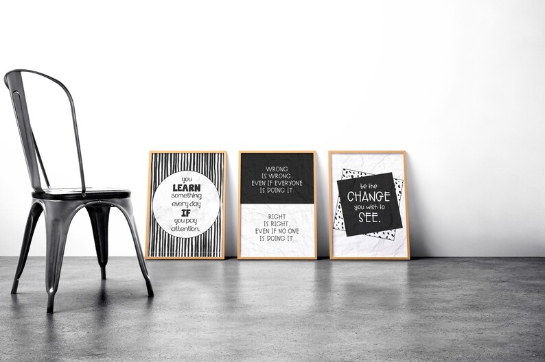 Op de afbeelding: Drie zwart-witte ingelijste prints met inspirerende citaten. De eerste print zegt "Je leert elke dag iets als je oplet." De tweede print zegt "Fout is fout, zelfs als iedereen het doet. Goed is goed, zelfs als niemand het doet." De derde print zegt "Wees de verandering die je wilt zien."
