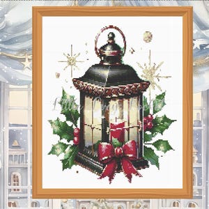 May include: A black lantern with a red bow and holly leaves. The lantern has a candle inside and is surrounded by a white background.
