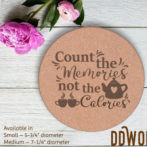 Puede incluir: Posavasos de corcho con el texto "Count the Memories not the Calories" en letras marrones. El posavasos presenta una tetera marrón con un corazón y dos tazas de café marrones con vapor. El posavasos está disponible en dos tamaños: 5-3/4 pulgadas y 7-1/4 pulgadas de diámetro.