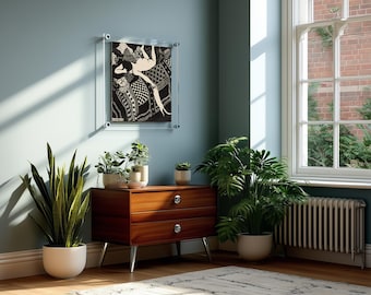May include: A rectangular wall art piece featuring a black and white graphic illustration of a figure lying on a patterned surface, encased in a clear acrylic frame with four silver mounting bolts at the corners, mounted on a blue wall.