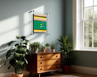 May include: A rectangular artwork encased in a clear acrylic floating frame, featuring horizontal stripes in beige, black, and yellow, with a central green band containing a single yellow tulip illustration and small red accents at the bottom edge.