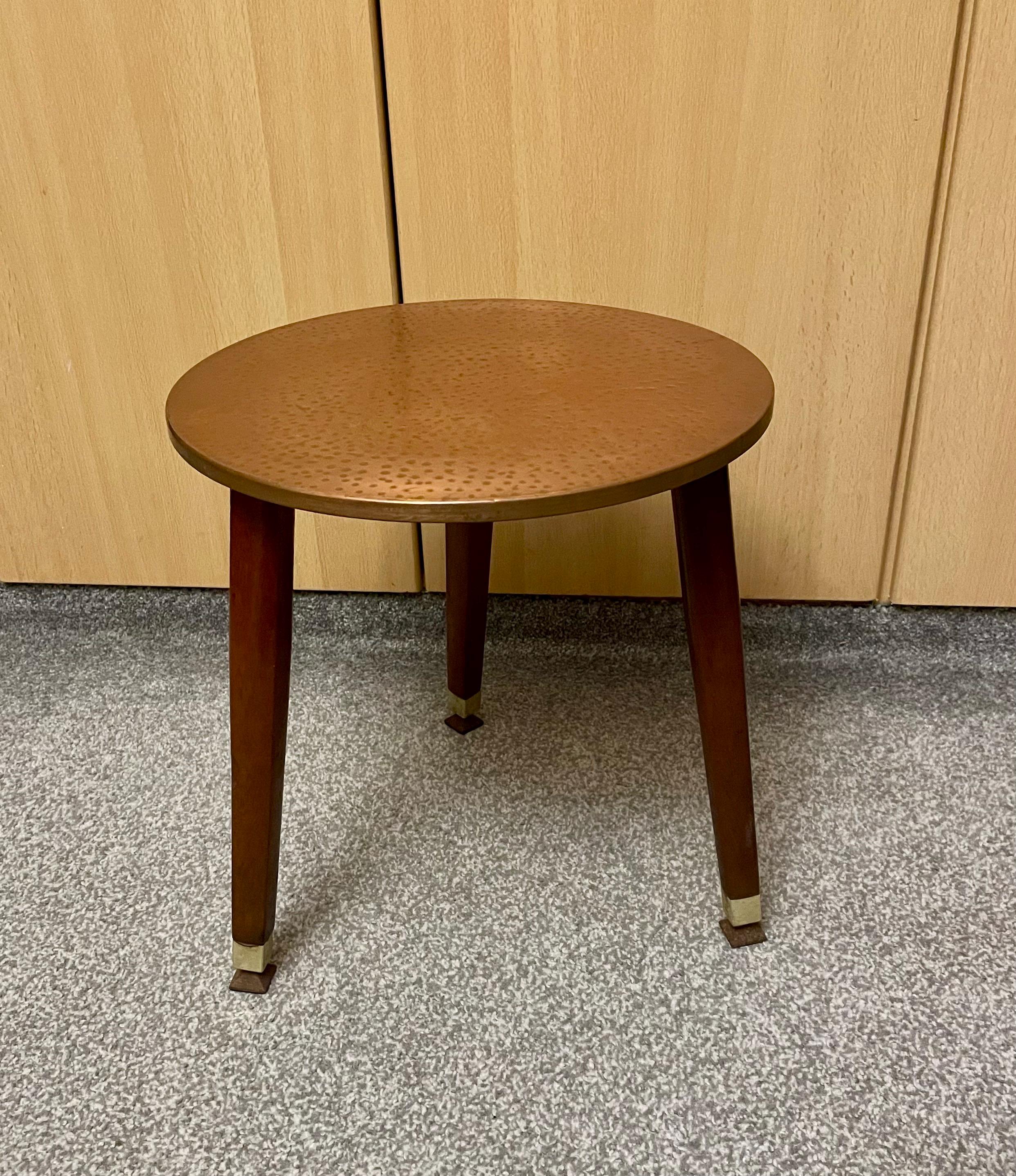 Vintage coffee table with hammered copper top and wooden legs.