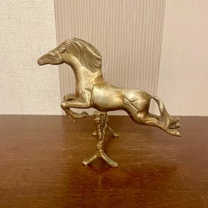 Vintage solid brass horse jumping over the fence. Brass leaping horse statuette.