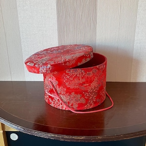Vintage runde Box außen mit Satin im orientalischen Stil bezogen und innen mit rotem Stoff bezogen.