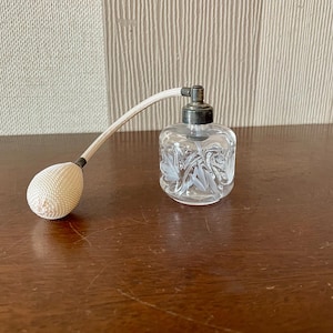 Vintage glass perfume bottle with a spray dispenser.