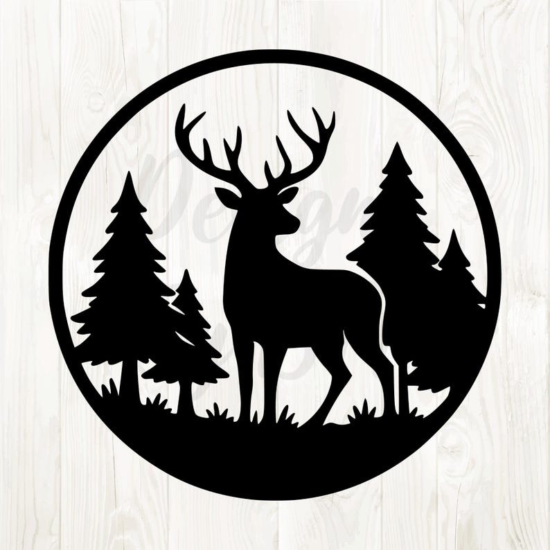 May include: Black silhouette of a deer with large antlers standing in a forest scene, framed by a circular border. The design includes pine trees and grass, creating a nature-themed image.