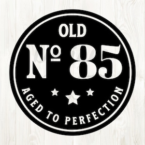 Puede incluir: Diseño circular en blanco y negro con el texto "OLD No 85 AGED TO PERFECTION" en un círculo blanco sobre fondo negro.