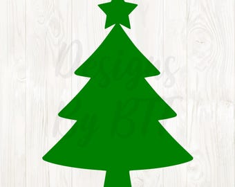 May include: A green Christmas tree silhouette with a star on top. The tree has a classic shape with three tiers of branches. The background is a white wooden surface.