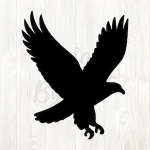 May include: A black silhouette of an eagle in flight, wings spread wide. The bird's talons are extended, and its beak is slightly open. The image is set against a light wood grain background.