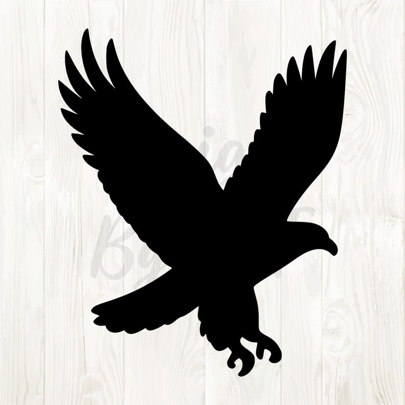 May include: A black silhouette of an eagle in flight, wings spread wide. The bird's talons are extended, and its beak is slightly open. The image is set against a light wood grain background.