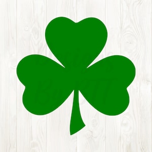 May include: A bright green shamrock illustration with three heart-shaped leaves and a stem. The shamrock is set against a white wood grain background. The image is a simple, clean design, perfect for St. Patrick's Day.