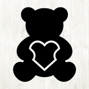 May include: Black silhouette of a teddy bear holding a heart-shaped shield. The bear is sitting with its arms around the heart. The background is a light wood grain pattern.