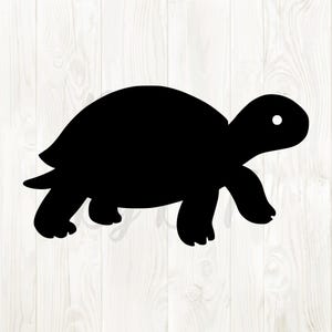 Puede incluir: Una silueta negra de una tortuga caminando hacia la izquierda. La tortuga tiene un caparazón redondeado, una cabeza pequeña con un solo ojo blanco y cuatro patas. El fondo es un patrón de vetas de madera clara.