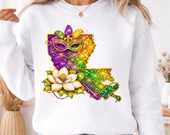 May include: White sweatshirt featuring a colorful design of the Louisiana state outline, a Mardi Gras mask, and a white flower. The design incorporates purple, green, and gold glitter effects, with a gold outline. A festive and celebratory theme.