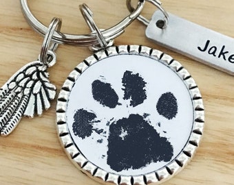May include: Silver keychain with a paw print charm, a small angel wing charm, and a tag that says "Jake".